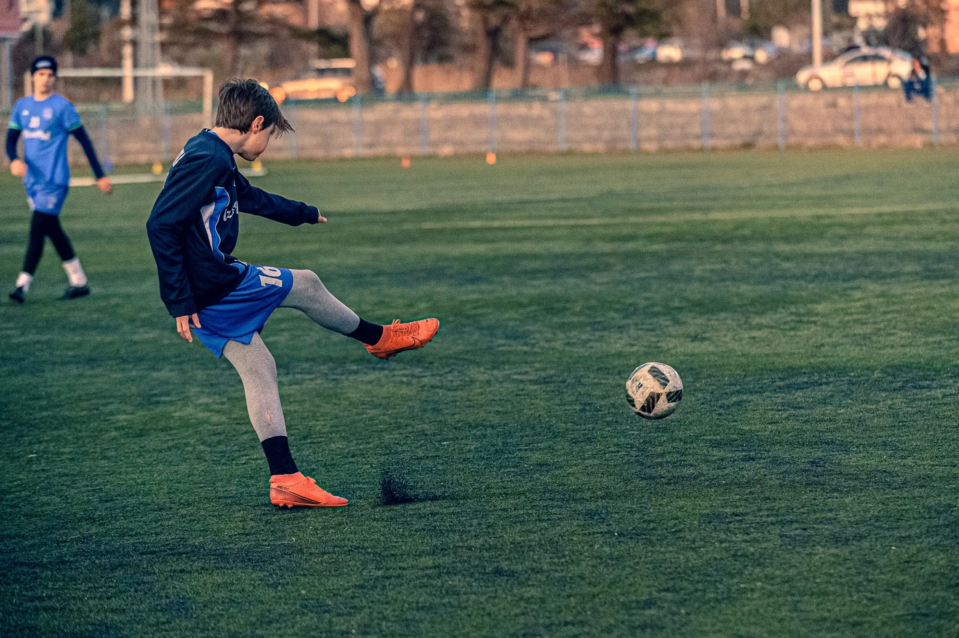 A child kicking a soccer ball outdoors